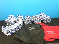 All napkin bundles, red apron, black apron displayed on surface