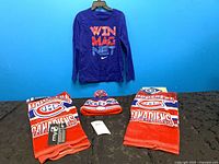 Lot overview showing Nike tee, toque on mannequin head and two hand towels