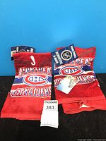 Two red Montreal Canadiens hand towels with tags