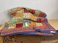 Quilt folded showing multicolor patchwork front and label tag