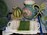 View of the large pitcher, asparagus platter, covered jar, and plates showing colorful Majolica style pottery