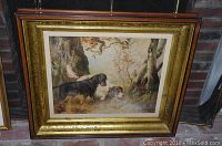 Framed chromolithograph of hunting dogs, showing the full frame and glass cover.