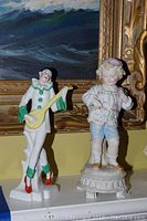 Two intact figurines (Pierrot and standing child) displayed side by side