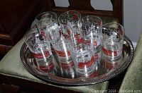 Seven Pennsylvania Railroad commemorative glasses displayed on a silver tray, showing the overall number and design of the glasses.
