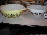 Two Pyrex mixing bowls side by side showing Gooseberry Black design, yellow exterior and white interior
