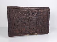 Front view showing relief carving of village scene