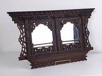 Front view showing full carved frame and two mirrors