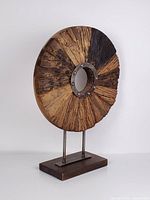 Front angled view of wood disc sculpture on stand