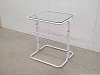 Full view of white metal side table showing glass top and frame