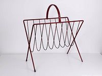 Overall view of red metal magazine rack angled side