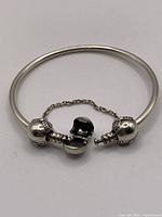 Bangle bracelet open showing clasp and attached safety chain
