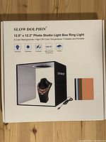 Retail box showing Slow Dolphin 12.9" × 12.2" photo studio light box ring light, backdrop colours and USB cable