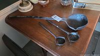 All three ladles on table showing size differences
