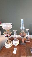 Group shot of the four antique oil lamps on table