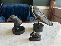 Group shot of three bronze animal sculptures on marble surface