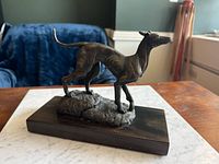 Left side view of bronze greyhound on wood mount