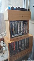 Two wooden crates stacked containing DVDs and CDs