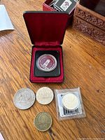 Group shot of all five coins including boxed and sealed pieces