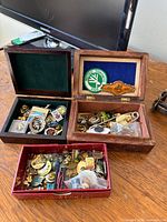 Three open boxes showing large quantity of assorted pins and badges
