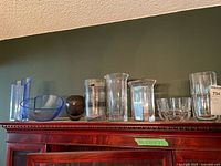 All eight glass pieces lined up on cabinet