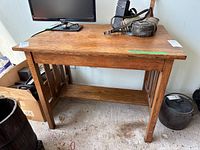 Front view of solid wood table with slatted sides and accessories on top (not included)