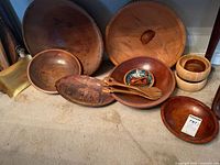 Group shot of all wooden bowls, platters, tray, utensils and small ceramic dish