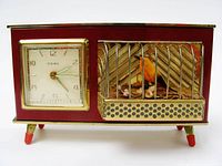 Front view showing clock face, bird cage and overall condition