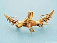 Front view of 9K gold crescent moon brooch showing bow and bead details