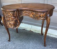 Front and side view of carved kidney-shaped desk