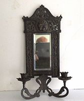Full view of cast iron mirror with candle holders attached