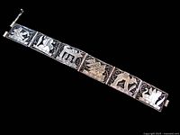 Front view of full bracelet showing six Egyptian motif panels and clasp