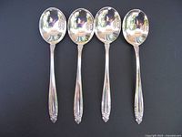 Front view of four sterling Prelude soup spoons