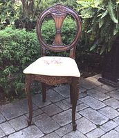 Full view of carved wooden desk chair on patio setting