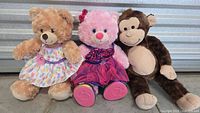 Group shot of all three Build-A-Bear plush toys seated side by side