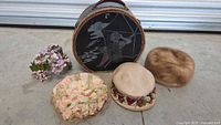 Group shot of four hats and hat box