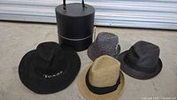 Group shot: four hats and black round hat box