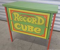 Front view showing "Record Cube" painted panel and leg colors