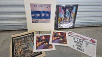 All six prints laid out: cityscape, abstract, Egyptian, humorous sign, two figuratives