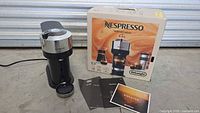 Coffee maker with box, manuals and drip tray visible