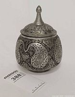 Front view of lidded silver on copper container showing overall form and decoration