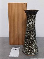 Vase standing beside wooden box