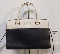 Front view showing colorblock design, handles, logo plate