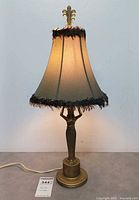 Full view of lamp illuminated showing shade, base and cord
