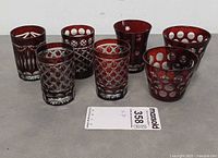 Seven ruby cut-to-clear shot glasses front view