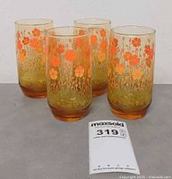 Four amber glasses showing floral design and height