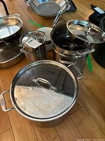 Group of All-Clad pots showing lids and inserts