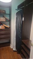 Closet view showing garment bag containing Wayne Clark dress