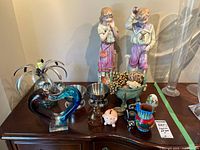 All items on dresser including figurines, glass heart, metal sculpture, bowls and decor