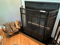 Fireplace screen and log rack beside fireplace