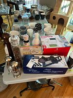 Wide view showing boxed slicers, cutters and several seasoning mills on table